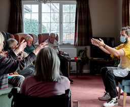 Residents doing seated exercise in the lounge